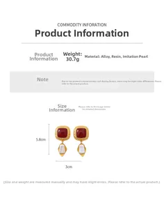 Detail view of vintage resin earrings with gold frame, red accents and pearl drops