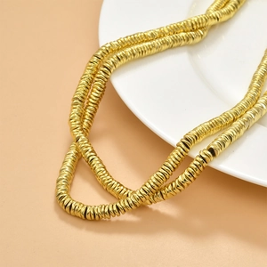 Macro view of golden hematite wave spacer beads for DIY jewelry making and necklace crafts