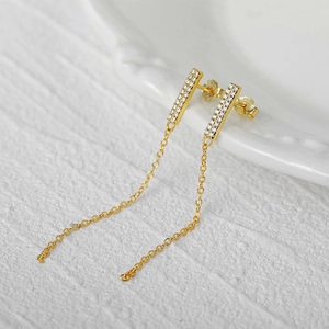 Macro detail of 925 silver gold tassel earrings with micro-inlaid cubic zirconia stones