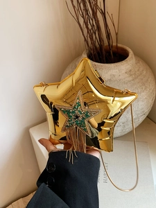 Detail shot of golden star-shaped acrylic bag with sparkling rhinestones and long tassels
