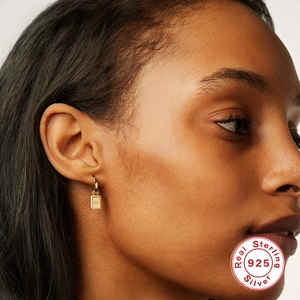 Elegance S925 sterling silver star square drop earrings worn by a model in gold finish