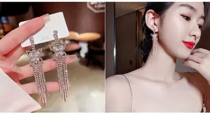 Macro detail of silver butterfly earrings with long rhinestone tassels on a model