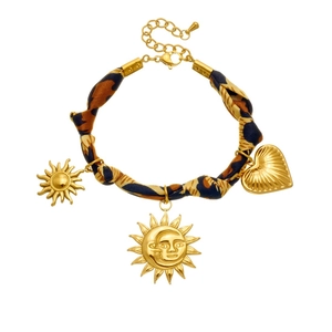 Leopard print ribbon bracelet with gold sun and heart charms on a clean white backdrop
