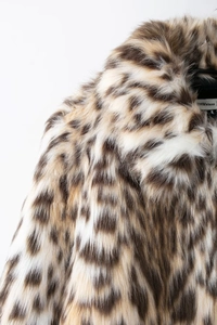 Detailed macro view of the luxurious leopard faux fur texture on a warm winter coat