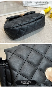 Detail of black quilted shoulder bag featuring gold twist lock and fine leather texture