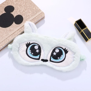 Detail of plush sleep mask with large cartoon eyes and star embroidery on white backdrop