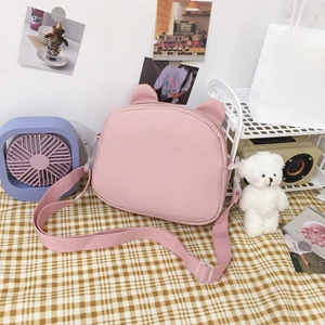 Cute pink canvas crossbody bag with animal ears design on a checkered tablecloth