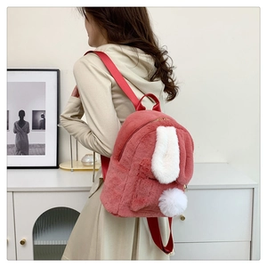 Side view of cute pink faux fur rabbit ear backpack worn by model in cozy home setting