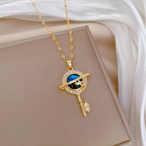 Gold key necklace with blue starry sky pendant and sparkling crystals on white silk