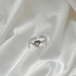 Minimalist 925 sterling silver open heart ring with beaded texture on white satin