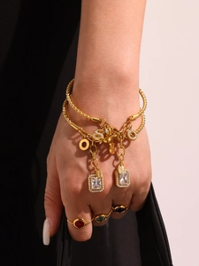 Macro shot of 18K gold plated stainless steel twisted bracelet with zircon pendants