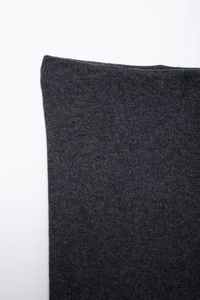 Detail of charcoal grey knit fabric texture showing fine diamond pattern stitching