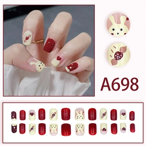 Cute bunny press-on nails in burgundy and beige with cartoon heart and dot patterns