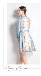 Side view of printed blue floral A-line dress with stand collar and silk belt detail