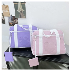 Detail view of purple and pink JK style ita bags with heart-shaped clear window and coin pouch