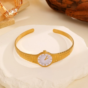 Macro detail of gold watch dial ornament on adjustable open ring with polished finish