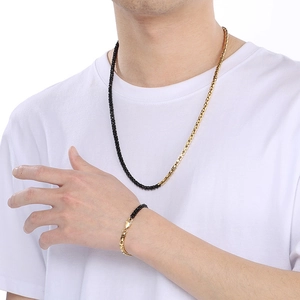 Two-tone black and gold stainless steel box chain necklace and bracelet set on model