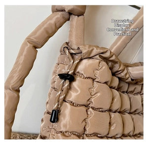 Detail of champagne quilted tote bag showing adjustable drawstring closure and satin finish
