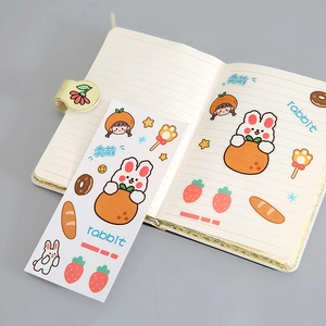 Cute cartoon rabbit PVC stickers with strawberry designs applied on a white notebook