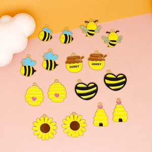Flat lay of colorful bee honeycomb and honey pot charms for DIY jewelry making
