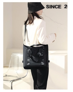 Minimalist black nylon tote bag with large capacity shown in a modern urban style setting