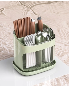Macro detail of a green multi-compartment kitchen utensil holder with a clear drip tray