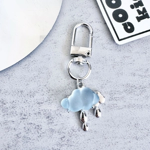 Detail of silver lightning cloud keychain with blue resin cloud and metallic raindrops