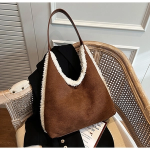 Brown suede tote bag with white faux fur trim styled on a vintage woven chair with a magazine