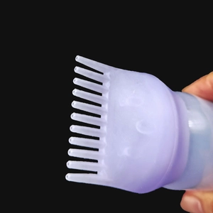 Macro shot of purple applicator comb nozzle for hair dye bottle on black background