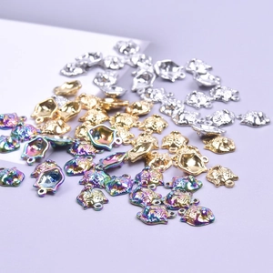 Detailed view of cat-shaped jewelry charms in gold, silver, and rainbow metal finishes