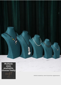 Five-tier emerald green velvet mannequin bust displays for necklace jewelry on marble surface