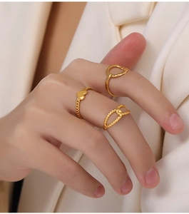 Detailed view of three gold-plated titanium steel rings featuring heart and textured designs