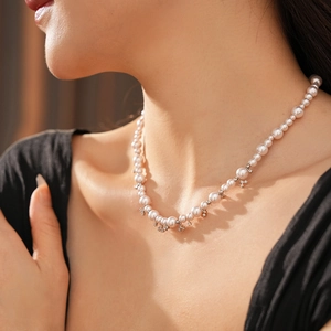 Close-up of pearl necklace featuring zircon floral accents on a graceful model's neck