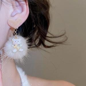 Close-up of model wearing heart fuzzy bear earrings with rhinestone heart and plush pompon