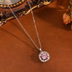 Detaillierte Nahaufnahme einer Silberhalskette mit rosa Edelstein und Schneeflocken-Anhänger