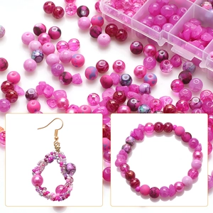 Detailed view of DIY jewelry kit with pink cracked glass beads and handmade bracelets