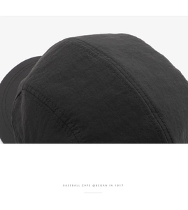 Macro detail of black quick-dry five-panel cap showing ripstop fabric and stitching