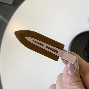 Detail of vintage bicolor resin hair clip showing the metallic duckbill clamp mechanism