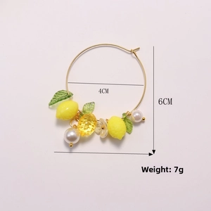 Detail showing 4cm yellow lemon drop earrings with pearl and leaf charms on gold rings