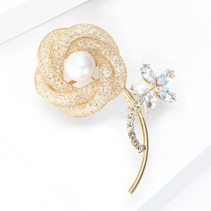 Elegant gold hollow rose brooch with pearls and crystals on white geometric stand
