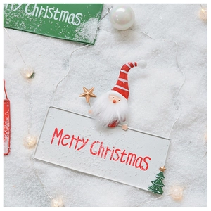 Macro detail of metal Santa Merry Christmas sign with plush beard on snowy background