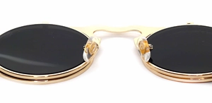 Macro detail of gold metal steampunk sunglasses bridge with signature logo nose pads