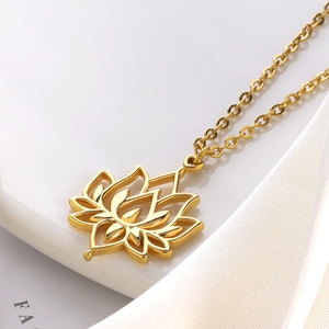Macro shot of gold hollow lotus pendant necklace on white silk ribbon background