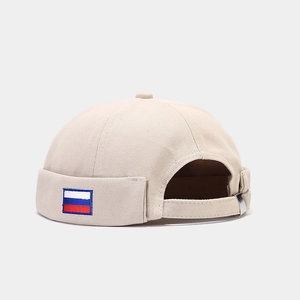 Detail view of the adjustable metal buckle and Russian flag patch on the beige docker cap