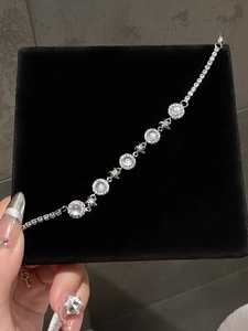 Detail of flower-shaped chalcedony bracelet with zircon pavé on black velvet box