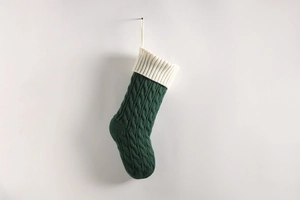 Macro detail of green cable-knit Christmas stocking with white cuff and texture