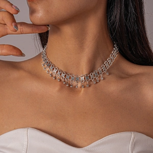 Detailed macro view of retro silver beaded choker with engraved floral metal patterns