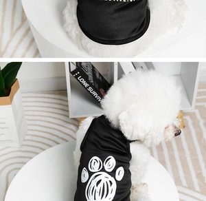 Close-up of black breathable pet vest with white paw print and dog model wearing it
