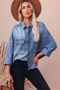 Close-up of vintage washed denim shirt featuring double chest pockets and metal buttons
