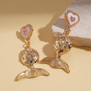 Detail of pink heart and gold fish earrings with sparkling rhinestones on stone base